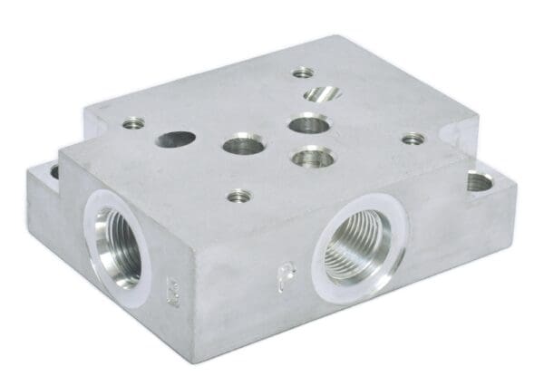 A silver block with two holes and three different valves.