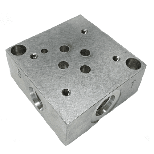 A metal block with holes for the valves.